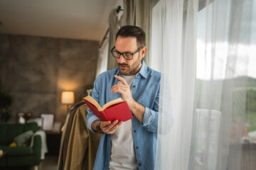 Wall Mural - Portrait of adult man read book at living room happy and relax