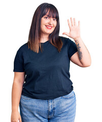 Sticker - Young plus size woman wearing casual clothes showing and pointing up with fingers number five while smiling confident and happy.