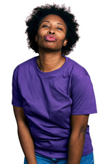 Wall Mural - African american woman with afro hair wearing casual purple t shirt looking at the camera blowing a kiss on air being lovely and sexy. love expression.