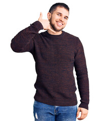 Sticker - Young handsome man wearing casual sweater smiling doing phone gesture with hand and fingers like talking on the telephone. communicating concepts.