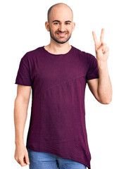 Canvas Print - Young handsome man wearing casual t shirt smiling with happy face winking at the camera doing victory sign. number two.