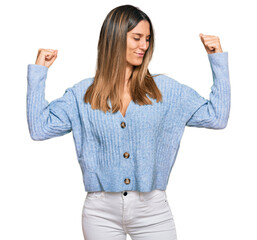 Wall Mural - Young woman wearing casual clothes showing arms muscles smiling proud. fitness concept.