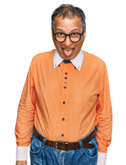 Poster - Middle age indian man wearing casual clothes and glasses sticking tongue out happy with funny expression. emotion concept.