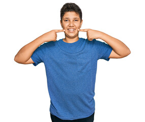 Wall Mural - Teenager hispanic boy wearing casual clothes smiling cheerful showing and pointing with fingers teeth and mouth. dental health concept.