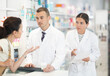 © JackF - Man and woman pharmacists looking for prescription medicine for adult woman using computer