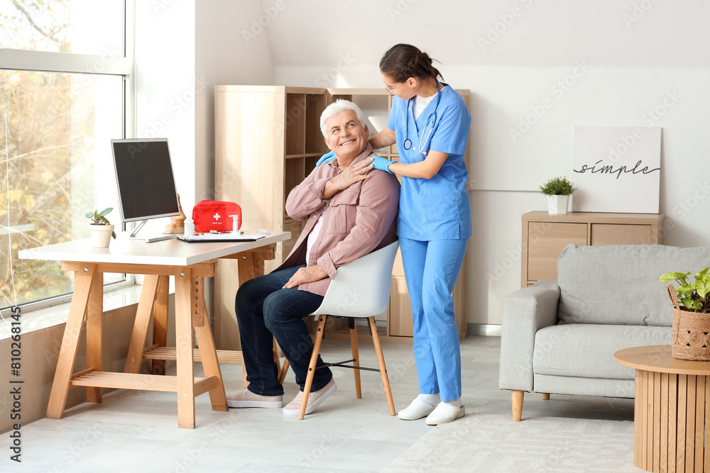 Happy senior man with nurse at home