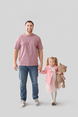 Poster - Happy father and his cute little daughter with teddy bear on grey background