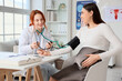 © Pixel-Shot - Young pregnant woman with doctor measuring blood pressure in clinic