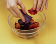 Female hands holding colorful potato and other vegetables chips inside glass bowl