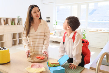Wall Mural - Happy mother with her little son making sandwich for school lunch in kitchen