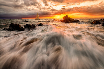 Wall Mural - Sunset sailing: seascape with rushing waves and yacht
