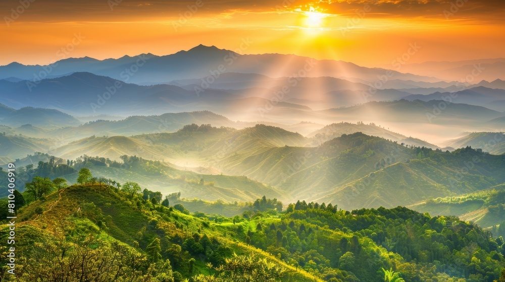 Sunrise casting golden light over a series of rolling hills and misty ...
