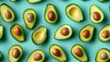 Fun pattern of whole and sliced avocados, meticulously arranged on a bright cyan backdrop, shot from above with studio lights