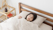 ベッドで寝るアジア人女性	