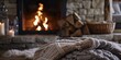 © inspiretta - blanket is laying on the floor next to a fireplace with a lit candle in the background and a basket of logs