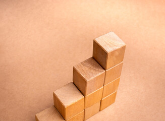 Poster - Blank wooden cube blocks bar graph chart four steps, isolated on brown recycle paper background, investment, income, inflation, business growth, economic improvement concepts, eco-friendly style.