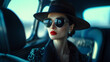 © NaphakStudio - Fashion portrait of a sophisticated woman wearing a wide-brimmed hat and sunglasses, seated in a luxurious car interior.
