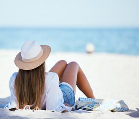 Wall Mural - Travel, beach and woman relax by ocean for summer vacation, holiday and tropical island. Nature, tourism and person on towel sunbathing for resting at seaside, sunshine and adventure in Hawaii