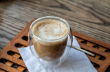 Fototapeta Natura - A glass cup of cappuccino coffee on the table.