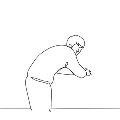 man stands leaning forward leaning on crossed elbows and turned around and looks at the camera - one line art vector. concept lonely man standing, hunched back	