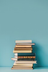 Wall Mural - A stack of books on a blue background