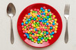cutlery on table and sweet plate of candy. Health and obesity concept, top view on colored background