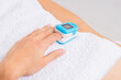 Woman using pulse oximeter at home. Female hand and medical equipment. Healthcare concept.
