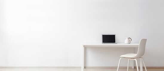 Poster - A white table with a chair and a laptop creating a minimalist setting with copy space image
