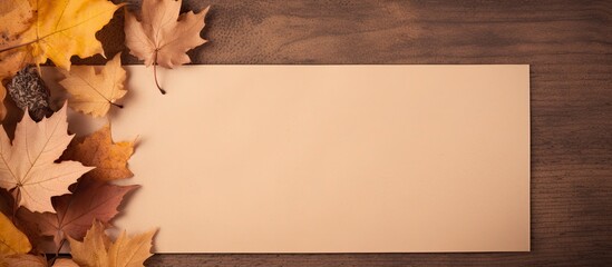 Poster - Top view of blank memo paper on brown kraft paper background adorned with dry autumn leaves Perfect for adding text or images. Creative banner. Copyspace image