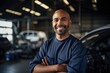 © photolas - Smiling master in the factory shop among machines and repair equipment. A man mechanic specialist on the background of the workshop, garage.