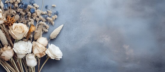 Poster - A copy space image of blue and white dried flowers arranged in brown wrapping paper on a wooden table against a gray cement backdrop