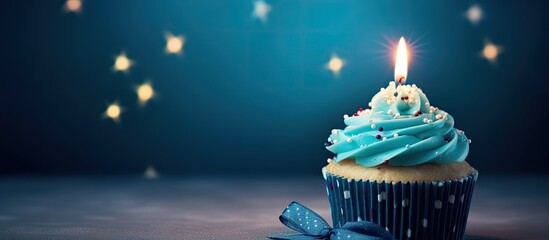 Aufkleber - A homemade cupcake with a lit candle is placed on a simple background creating a cheerful birthday greeting card The copy space image also includes a gift box for the birthday holiday celebration