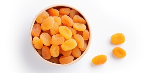 Aufkleber - Copy space image of a top view bowl filled with dried apricots on a white background offering a healthy and nutritious fruit option