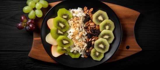 Poster - A wholesome breakfast consisting of oatmeal kiwi cottage cheese and raisins is presented on a black plate set against a dark wooden backdrop This image conveys the idea of a healthy breakfast as seen