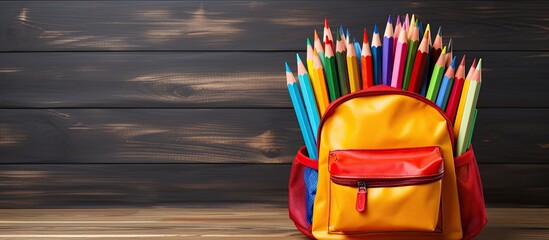 Poster - A drawing set consisting of colorful pencils is stored in the pocket of a school bag against a wooden wall backdrop with room for additional images and text Perfect for artists and students returning