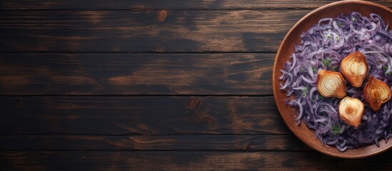Poster - A top view close up of a plate on a wooden table with a copy space image of fried blue cabbage onion apple and garlic