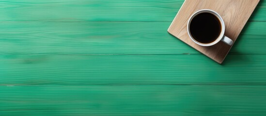 Poster - A top view of a wooden desk with a green screen smartphone and a paper coffee cup providing ample copy space in the image