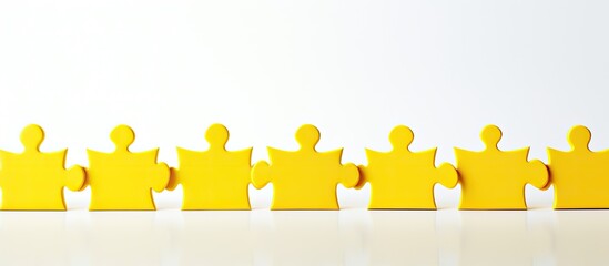 Poster - A lineup of yellow puzzle pieces on a textured white background emphasizing the concept of teamwork Copy space image available