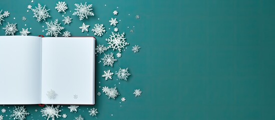Fototapete - The image depicts an open notebook alongside delicate snowflakes set against a vibrant green background This top down view offers ample space for personalization or additional elements