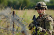 A soldier is standing in a field with a rifle. Concept of duty and readiness, as the soldier is prepared to protect and serve
