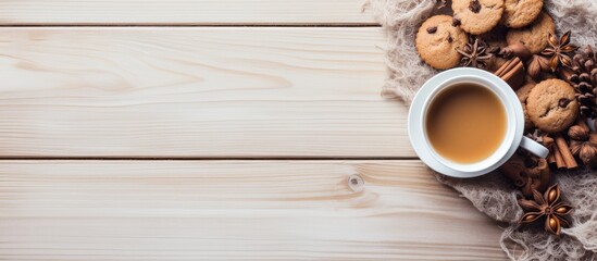 Poster - Hello winter A cozy scene unfolds on a light wooden background featuring a cup of tea a scarf delectable cookies and tempting hazelnuts Perfect for a copy space image