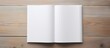© HN Works - A blank book cover template with an open page on the front side positioned on a white wood background in a flat lay copy space image