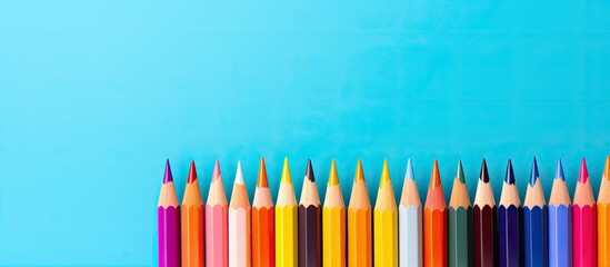 Poster - A vibrant arrangement of colored pencils against a pastel backdrop creating a visually captivating copy space image