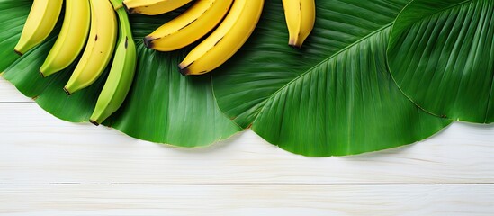 Aufkleber - a tropical fruit the banana is placed on a white wooden table alongside vibrant green leaves the top