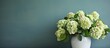 © HN Works - A green wall serves as the backdrop for a close up image of hydrangea flowers arranged in a ceramic vase Copy space is available