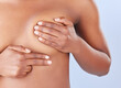 © peopleimages.com - Woman, hands and exam breast in studio, health and check for cancer in assessment on blue background. Female person, fingers and press for self diagnosis or prevention of disease, early sign and test