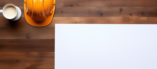Fototapete - A top down view of a brown wooden table displaying a white sheet of paper alongside an orange safety helmet a notepad or notebook and a cup of coffee The image offers ample space for text or any desi