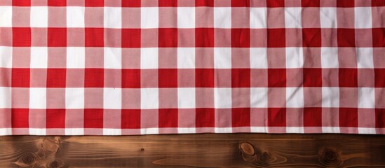 Wall Mural - A top view of a red and white checkered fabric texture on an old wooden background with copy space image The texture of the cotton fabric can be used as a background for designing a menu for a restau