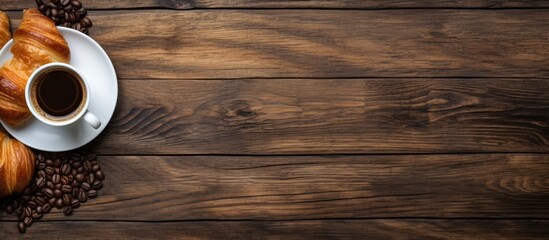 Poster - A top down view of a wooden table adorned with fresh croissants and a cup of coffee with ample space for additional elements