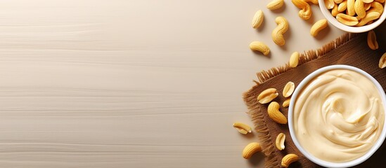Poster - A small bowl of creamy peanut pasta on a table with a background of peanuts and peanut butter Top view with copy space image
